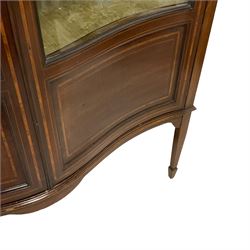 Edwardian inlaid mahogany serpentine display cabinet, projecting cornice over satinwood banding and stringing, enclosed by two glazed serpentine doors with panels to base, raised on square tapering supports with spade feet