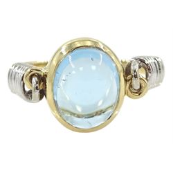 14ct gold blue topaz ring, oval cabochon blue topaz in a swivel setting two coiled shoulders, stamped