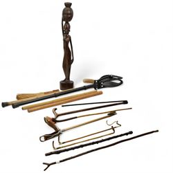 Two crops with horn handles and silver ferrules, silver topped ebonised swagger stick and various other sicks, hunting sticks, etc, together with a carved hardwood figure