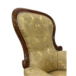 Victorian mahogany framed armchair, shaped and moulded frame carved with curled foliage, upholstered in pale gold floral pattern silk damask fabric, scrolled arm terminals on shaped moulded supports terminating to scroll carved feet