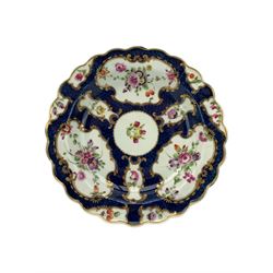 18th century Worcester tea caddy, of oval form and painted in the Kakiemon palette with reserves of flowers against a blue scale ground, H14cm together with a similar Worcester circular dish, painted with floral sprays, within a scalloped edge, blue crescent mark beneath, D19cm (2)