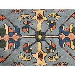 Turkish indigo ground rug, the shaped central field decorated with a central geometric stylised plant motif, enclosed with a guarded border decorated with contrasting motifs 