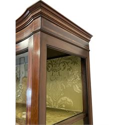 Edwardian inlaid mahogany serpentine display cabinet, projecting cornice over satinwood banding and stringing, enclosed by two glazed serpentine doors with panels to base, raised on square tapering supports with spade feet