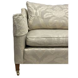 Duresta - Grande hardwood-framed three-seat sofa, upholstered in pale fabric decorated with repeating foliate pattern, on square tapering supports with brass castors 