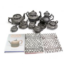 Early 19th century and later black basalt tea wares, mostly with relief or engine-turned bodies, including a large Cyples teapot with dog finial and scroll handle, a similar coffee pot with lion finial, bachelors teapots etc and three related books in one box