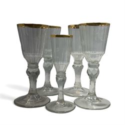 Set of four 19th century Baccarat liqueur/sherry glasses, circa 1820, with panelled bucket bowls and gilt rims, engraved CEG, to faceted knopped stems, together with another smaller example, H14cm and H12cm (5)