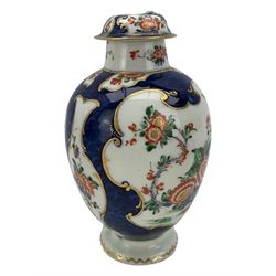 18th century Worcester tea caddy, of oval form and painted in the Kakiemon palette with reserves of flowers against a blue scale ground, H14cm together with a similar Worcester circular dish, painted with floral sprays, within a scalloped edge, blue crescent mark beneath, D19cm (2)