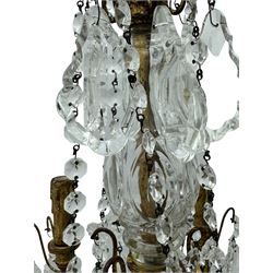 India Jane Interiors - brass and crystal six-branch chandelier, each branch holds a single candle-style bulb holder detailed with scrolling design, the chandelier is adorned with numerous crystal pendants and octagonal beads, which hang from each arm and from the cut crystal central column