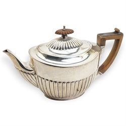 Victorian silver teapot of oval design with half body decoration, stained wood handle and lift London 1889 Maker Walter & John Barnard 