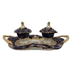 19th century porcelain inkstand, the oblong twin handled base centrally painted with a floral bouquet, flanked by two footed inkwells and covers, with rococo-inspired acanthus moulded borders and handles, pattern no. 2/3339, L26.5cm 