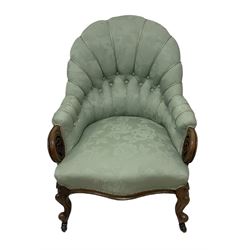 19th century mahogany framed fan-back armchair, upholstered in buttoned turquoise floral damask fabric with spring seat and pearlescent piping, pierced and carved arm terminals with floral motif, over serpentine fronted seat, raised on cartouche carved cabriole supports with castors