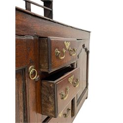 18th century oak dresser, projecting cornice over three heights plate rack with three small drawers, rectangular ovolo-moulded top over three central drawers and two flanking cupboards, enclosed by fielded panelled doors, on stile supports 