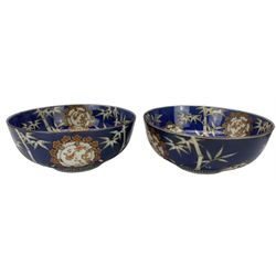 Set of four Japanese graduating porcelain bowls, each centrally painted with a coiled dragon in reserves, bamboo and foliate roundels against a blue ground, largest measuring D24.5cm (4)