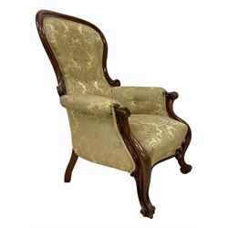 Victorian mahogany framed armchair, shaped and moulded frame carved with curled foliage, upholstered in pale gold floral pattern silk damask fabric, scrolled arm terminals on shaped moulded supports terminating to scroll carved feet