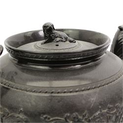 Early 19th century and later black basalt tea wares, mostly with relief or engine-turned bodies, including a large Cyples teapot with dog finial and scroll handle, a similar coffee pot with lion finial, bachelors teapots etc and three related books in one box