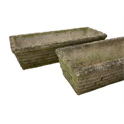 Three cast stone rusticated garden planters of tapering rectangular form 