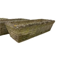 Three cast stone rusticated garden planters of tapering rectangular form 