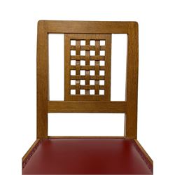 Mouseman - set of six (4+2) oak dining chairs, carved and pierced lattice back, oxblood leather upholstered seat with stud band, on octagonal front supports united by plain stretchers, each carved with mouse signature, by the workshop of Robert Thompson, Kilburn