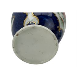 18th century Worcester tea caddy, of oval form and painted in the Kakiemon palette with reserves of flowers against a blue scale ground, H14cm together with a similar Worcester circular dish, painted with floral sprays, within a scalloped edge, blue crescent mark beneath, D19cm (2)