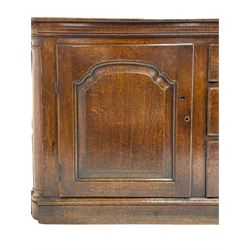 George III oak dresser base, rectangular top with rounded corners over moulded frieze rail, canted corners with turned quarter columns, fitted with three drawers with moulded edges flanked by two cupboards, enclosed by ogee arched fielded panelled doors, panelled sides, moulded plinth base