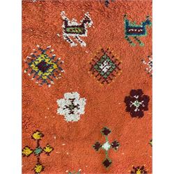 Moroccan amber ground thick pile rug, the field decorated with stylised geometric lozenges and roods, interspersed with camel motifs, the guard bands with stylised foliate and plant motifs