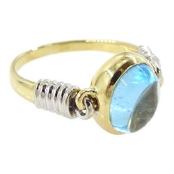 14ct gold blue topaz ring, oval cabochon blue topaz in a swivel setting two coiled shoulders, stamped