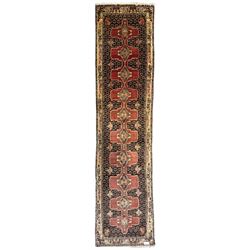 Kurdish rose ground runner rug, set with a series of ten floral medallions on linked field, the border decorated with stylised flower heads and bird motifs 