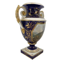 Early 19th century Derby porcelain urn, the reserve painted with a pastoral landscape and castle in the distance, with twin scroll and mask handles, upon a square pedestal base, H23cm, together with a Derby shell-shaped dish, centrally hand painted with a landscape scene titled 'In North Wales', within a cobalt blue and gilt border, L25cm (2)