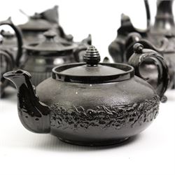 Early 19th century and later black basalt tea wares and similar stoneware, mostly with relief or engine turned bodies, including bachelors teapots, milk jugs, sucriers etc, in one box