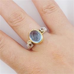 14ct gold blue topaz ring, oval cabochon blue topaz in a swivel setting two coiled shoulders, stamped