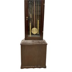 20th century - Westminster chime 8-day grandmother clock in a mahogany case, with a break arch top and brass finials, fully glazed trunk door with visible brass cased weights and pendulum, brass dial with etched dial centre and spandrels, chapter ring with Roman numerals and working moon disc to the arch, two train chain driven movement with 12 gong rods and chime selection for the quarters and hours.