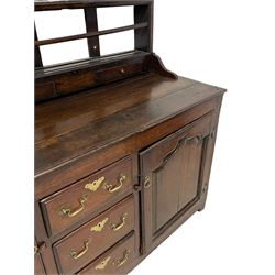 18th century oak dresser, projecting cornice over three heights plate rack with three small drawers, rectangular ovolo-moulded top over three central drawers and two flanking cupboards, enclosed by fielded panelled doors, on stile supports 