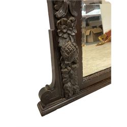 Victorian heavily carved oak wall mirror, projecting gadroon carved ovolo cornice, bevelled mirror plate within a lunette carved frame, decorated with applied fruit and foliage carved mounts, scroll carved brackets 