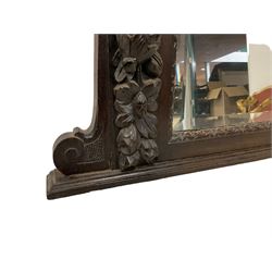 Victorian heavily carved oak wall mirror, projecting gadroon carved ovolo cornice, bevelled mirror plate within a lunette carved frame, decorated with applied fruit and foliage carved mounts, scroll carved brackets 