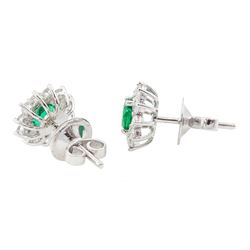 Pair of 18ct white gold emerald and round brilliant cut diamond cluster stud earrings, stamped, total emerald weight approx 0.90 carat, total diamond weight approx 0.65 carat