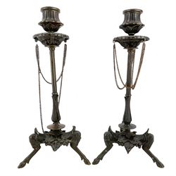 Pair of 19th century French patinated bronze candlesticks in the manner of Ferdinand Barbedienne, the gadrooned sconces hung with chains, reeded columns on tripod supports with hoof feet, H28cm 