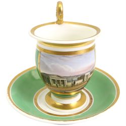 19th century French Empire design porcelain cup and saucer, the cup hand painetd with a panel, titled beneath 'Library, St Leonards, Near Hastings', against a green and gilt ground, cup H10.5cm 