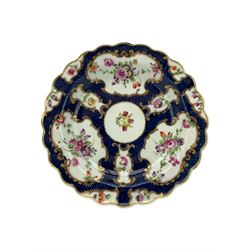 18th century Worcester tea caddy, of oval form and painted in the Kakiemon palette with reserves of flowers against a blue scale ground, H14cm together with a similar Worcester circular dish, painted with floral sprays, within a scalloped edge, blue crescent mark beneath, D19cm (2)