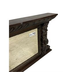 Victorian heavily carved oak wall mirror, projecting gadroon carved ovolo cornice, bevelled mirror plate within a lunette carved frame, decorated with applied fruit and foliage carved mounts, scroll carved brackets 