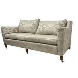 Duresta - Grande hardwood-framed three-seat sofa, upholstered in pale fabric decorated with repeating foliate pattern, on square tapering supports with brass castors 