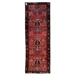 Persian crimson ground runner, the field decorated with stylised tree and animal motifs, indigo ground border decorated with alternating stylised flowerhead and bird motifs 