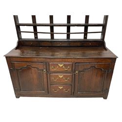 18th century oak dresser, projecting cornice over three heights plate rack with three small drawers, rectangular ovolo-moulded top over three central drawers and two flanking cupboards, enclosed by fielded panelled doors, on stile supports 