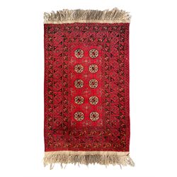 Afghan red ground Bokhara rug, decorated with four central Gul motifs, enclosed by wide geometric guard bands (191cm x 104cm); together with another similar (120cm x 79cm)