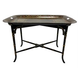 19th century tole ware tray of rectangular form, decorated with Japanese inspired floral motifs and gilt shells, with pierced handles, the associated ebonised and gilt stand, raised on ring turned splayed supports united by X-stretcher, decorated with gilt foliage