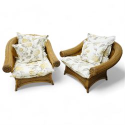 Pair of rattan cane work conservatory armchairs, with loose cushions upholstered in floral fabric