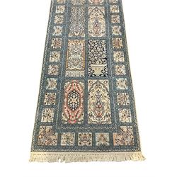 Fine Persian Kashmir ivory and pale indigo ground runner rug, the field decorated with sixteen rectangular panels depicting Mirab motifs and other traditional carpet designs, the border with repeating square panels of floral bouquets and foliate patterns