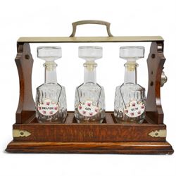 Early 20th century oak and silver plated tantalus, with matching moulded glass decanters and ceramic labels, L39cm