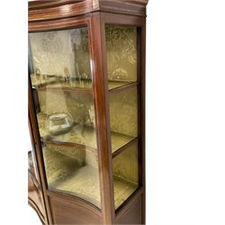 Edwardian inlaid mahogany serpentine display cabinet, projecting cornice over satinwood banding and stringing, enclosed by two glazed serpentine doors with panels to base, raised on square tapering supports with spade feet