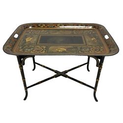 19th century tole ware tray of rectangular form, decorated with Japanese inspired floral motifs and gilt shells, with pierced handles, the associated ebonised and gilt stand, raised on ring turned splayed supports united by X-stretcher, decorated with gilt foliage