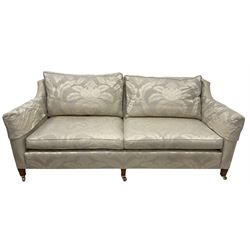 Duresta - Grande hardwood-framed three-seat sofa, upholstered in pale fabric decorated with repeating foliate pattern, on square tapering supports with brass castors 